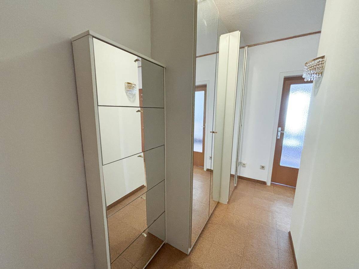 Flur mit Spiegelschränken und hellem Korkboden, der den Raum optisch erweitert.