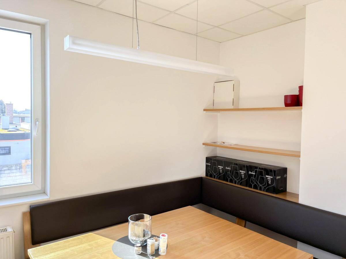Gemütlicher Essbereich mit Holztisch, Sitzbank und einem Fenster für natürliches Licht, perfekt für Pausen.