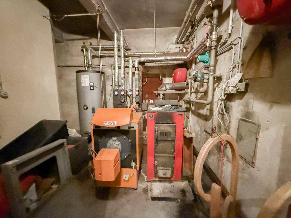 Heizungsraum im Keller mit verschiedenen Heizungsanlagen und Rohrleitungen.