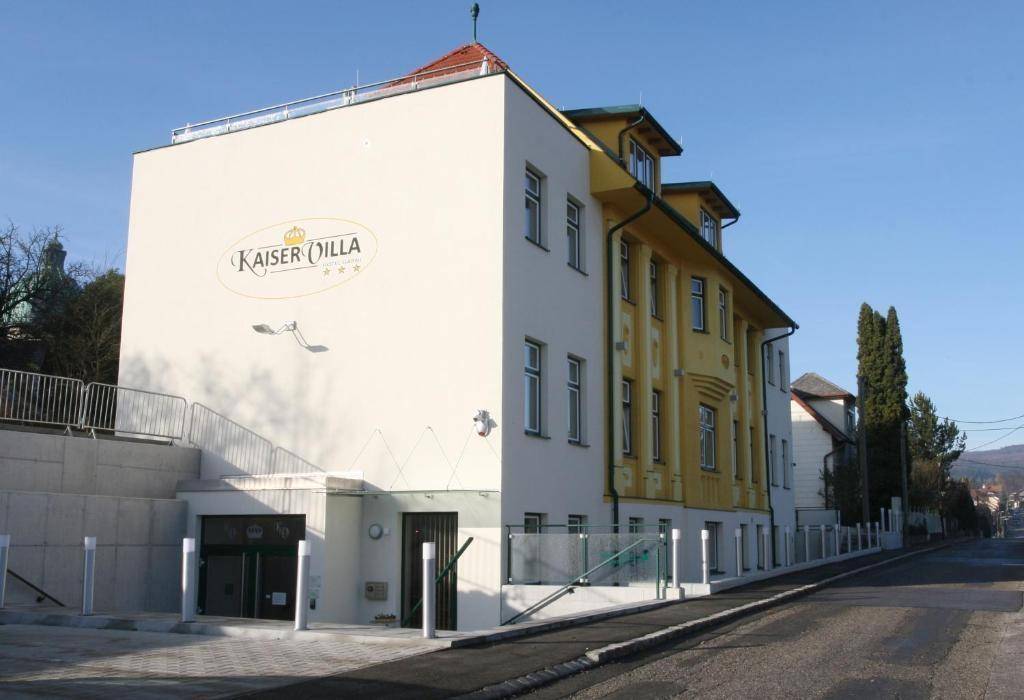 Seitenansicht des Gebäudes mit "Kaiser Villa" Schriftzug und Tiefgaragenzufahrt.