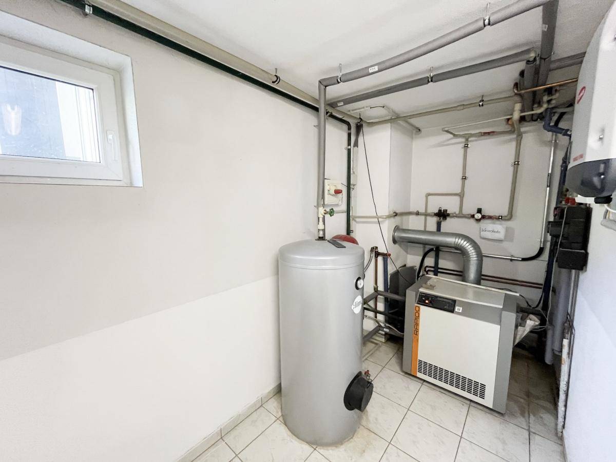 Technikraum mit Warmwasserspeicher und Heizungsanlage, gut zugänglich und funktional.