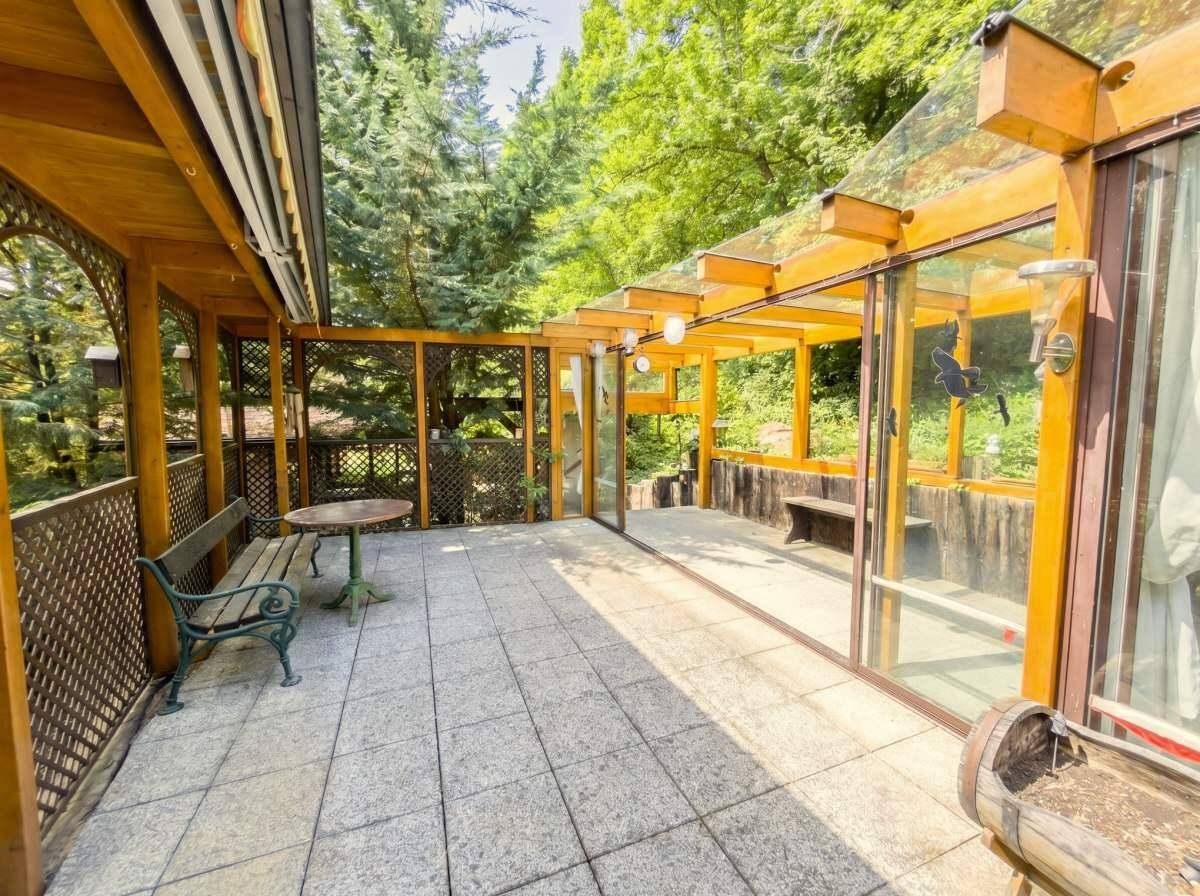 Geräumige Terrasse mit Fliesenboden und Holzelementen, ideal für Entspannung im Freien.