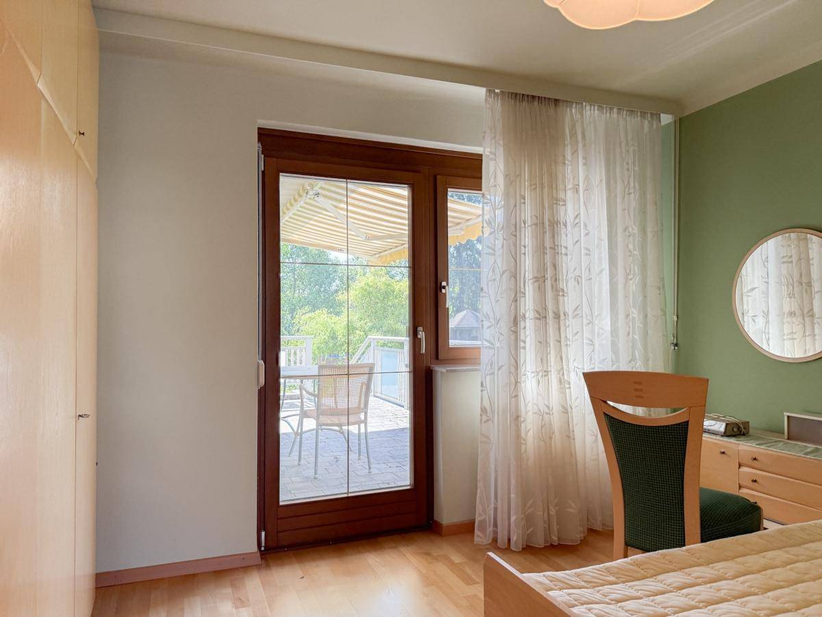 Schlafzimmer mit direktem Zugang zu einer Terrasse oder einem Balkon und Holzboden.