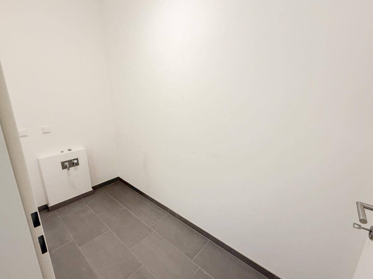 Kleiner Raum mit grauen Fliesen und Vorinstallationen für ein WC, ideal als Gäste-WC.