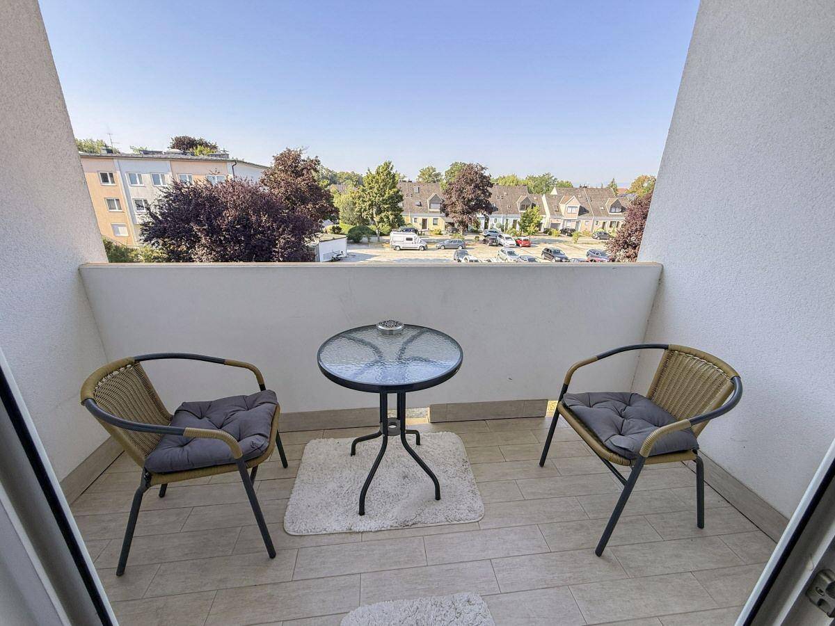 Gemütlicher Balkon mit Sitzgelegenheiten und Blick auf die umliegende Wohngegend.