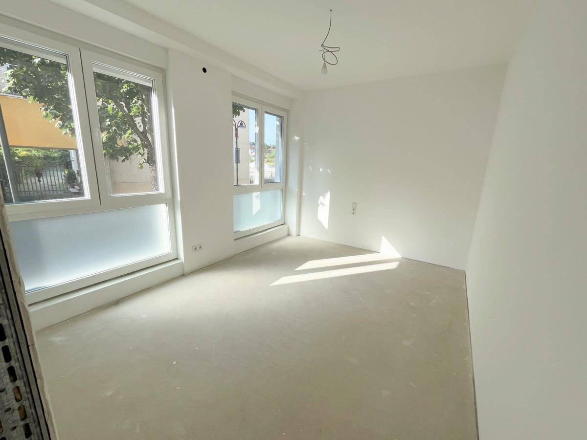 Helles Schlafzimmer mit großen Fenstern und viel Tageslicht, bereit für die Einrichtung.