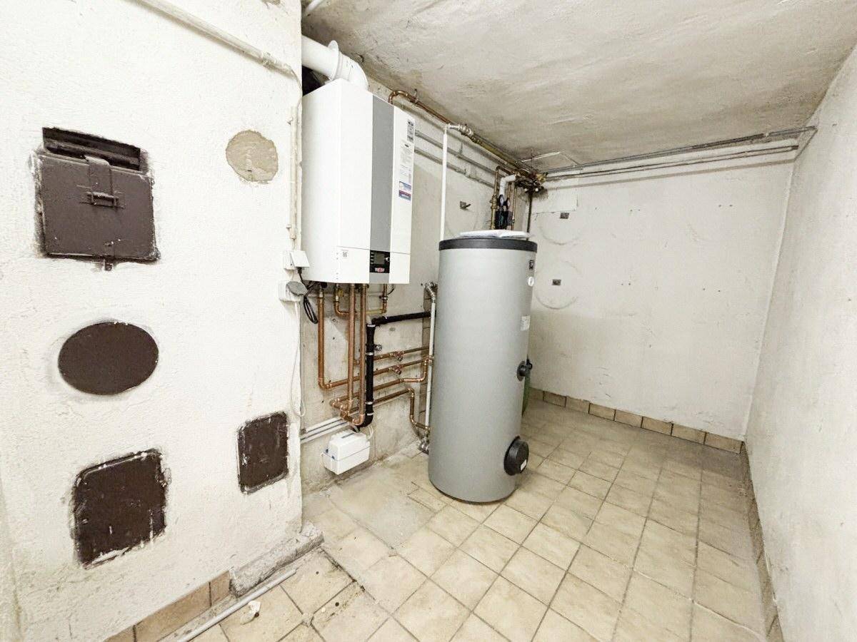 Heizraum im Keller mit moderner Heizungsanlage und Warmwasserspeicher.