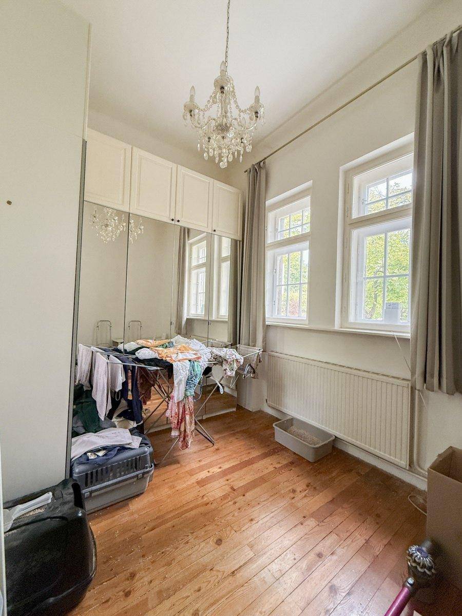 Helles Zimmer mit Holzdielenboden, Spiegelschränken und Kronleuchter.
