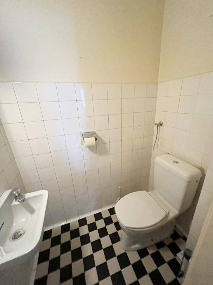 Kleines Gäste-WC mit schwarz-weiß karierten Fliesen, Toilette und Bidet.