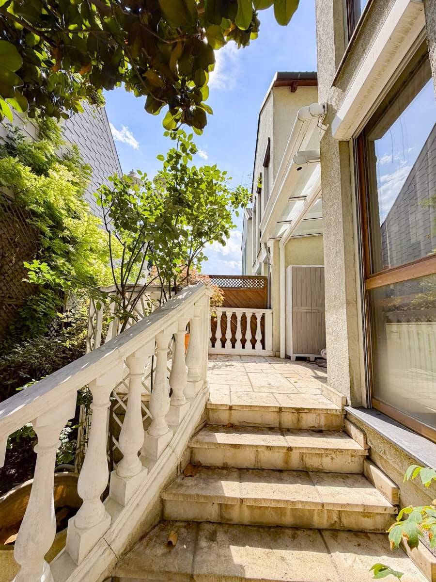 Steintreppe führt zu einer erhöhten Terrasse mit Balustrade und Blick ins Grüne.
