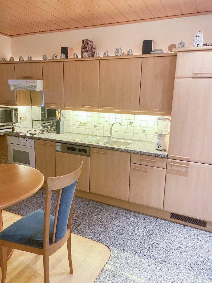 Funktionale Küche mit hellen Holzfronten, integrierten Geräten und ausreichend Stauraum.
