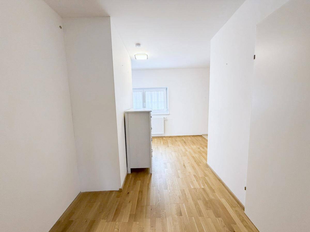 Geräumiges Schlafzimmer mit Holzboden und viel Tageslicht, bereit zur Einrichtung.