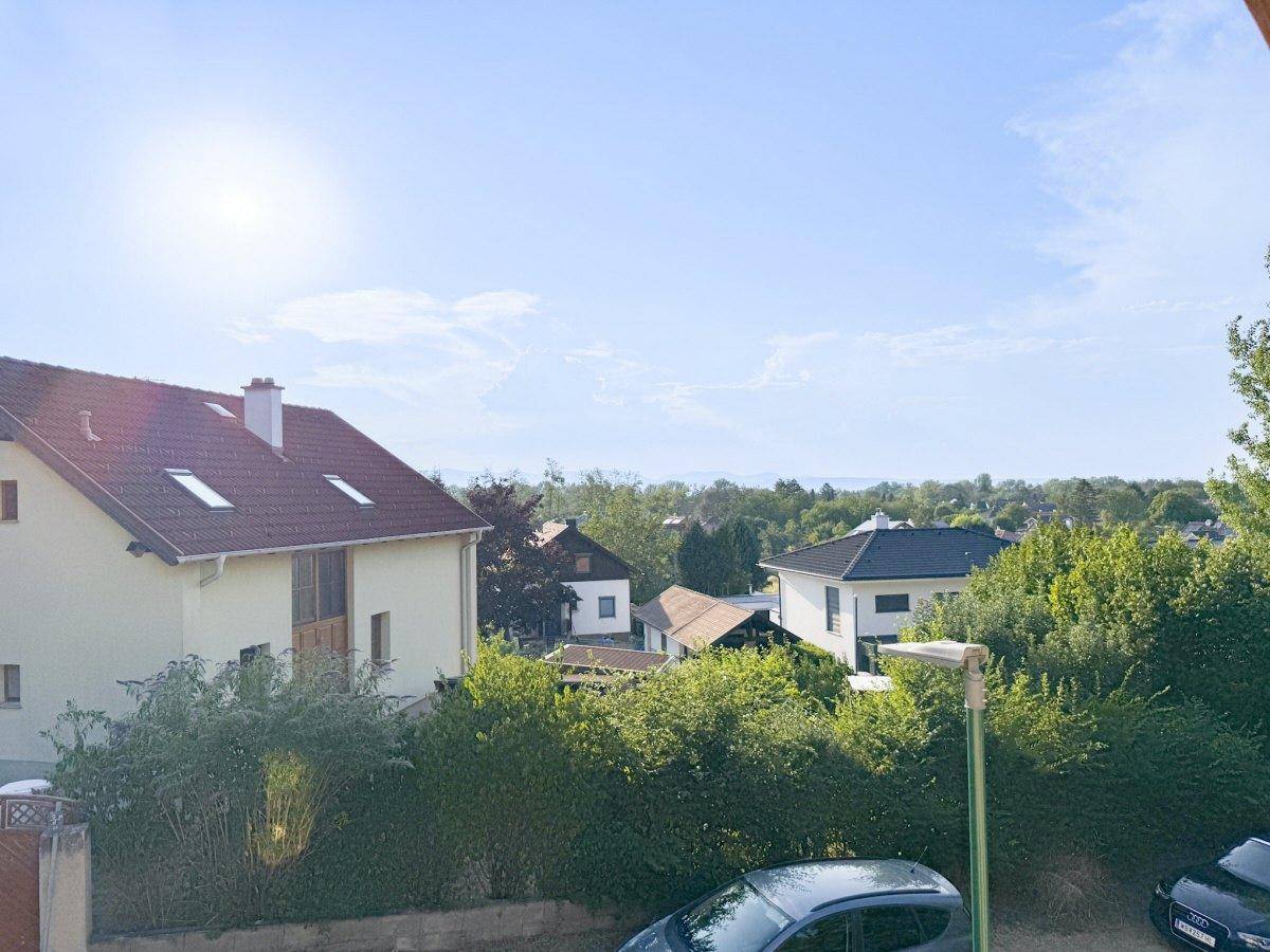 Weitblick über die Dächer der Nachbarschaft und die umliegende grüne Landschaft.
