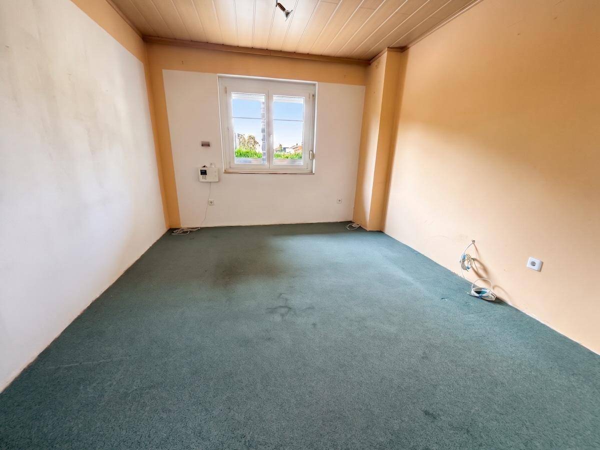 Schlafzimmer mit Teppichboden, Holzdecke und Fenster, das auf die Umgebung blickt.