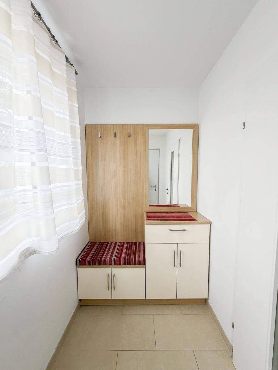 Eingangsbereich mit Garderobe, Spiegel und praktischen Schränken.