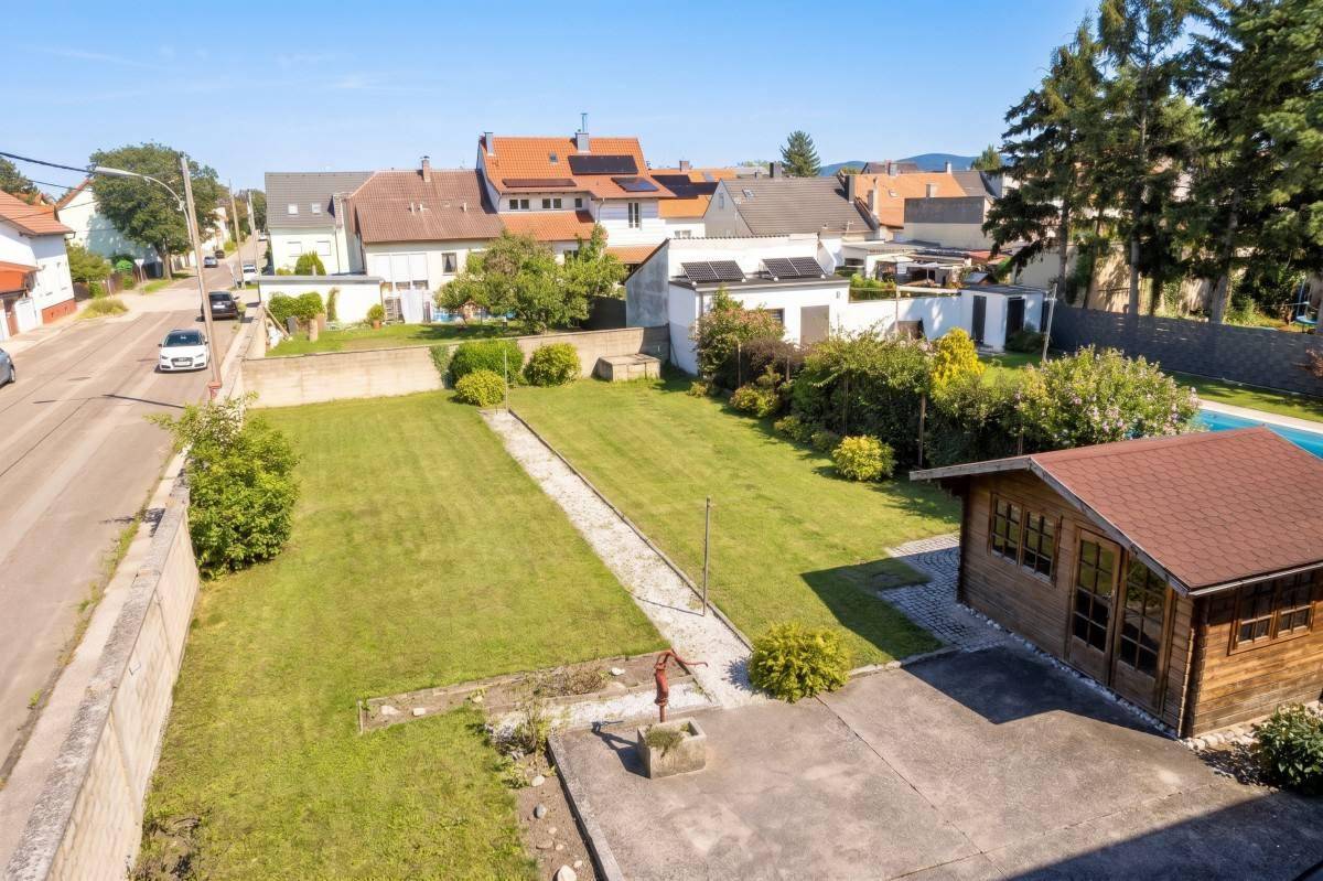 Luftaufnahme des Grundstücks mit Garten, Gartenhaus und angrenzender Straße.