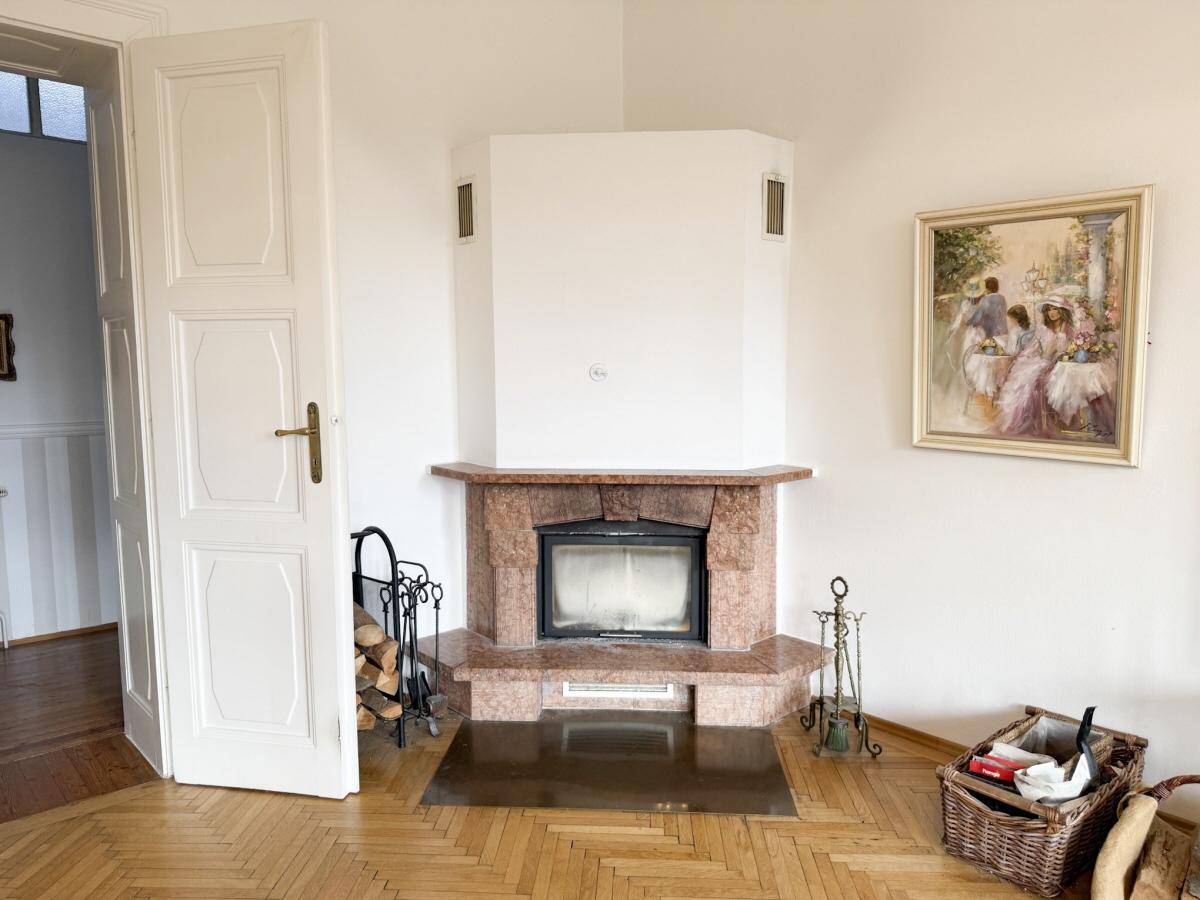 Gemütlicher Wohnbereich mit einem Kamin aus Marmor und Holzparkettboden.