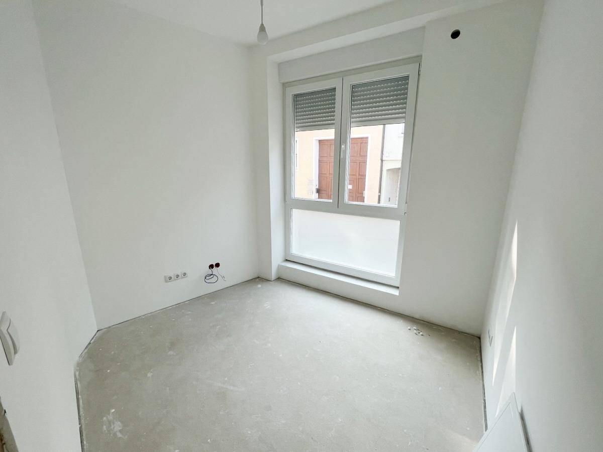 Leeres Zimmer mit Fenster und Rollladen, bereit für die individuelle Gestaltung.