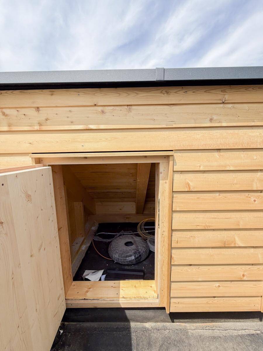 Offener Holzschrank auf der Dachterrasse, bietet praktischen Stauraum im Außenbereich.
