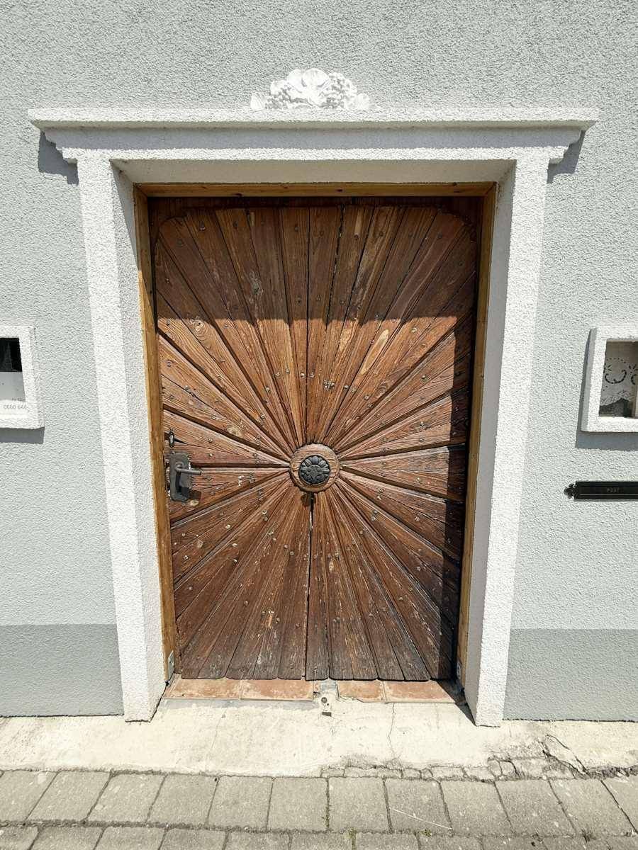 Detailansicht einer kunstvoll geschnitzten Holztür mit Sonnenstrahlenmuster.