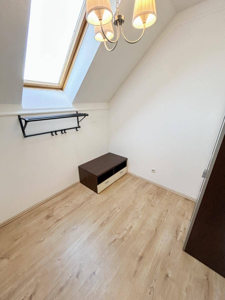 Helles Zimmer mit Dachfenster, Holzboden und Dachschräge.