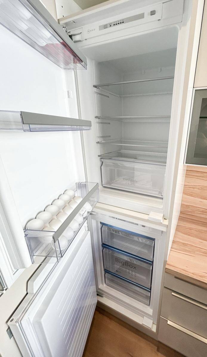 Offener Kühlschrank mit mehreren Fächern und Gefrierbereich, ideal für die Lebensmittelaufbewahrung.