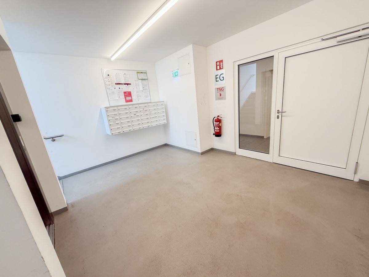 Heller Gemeinschaftsbereich im Erdgeschoss mit Briefkästen und Zugang zum Treppenhaus.