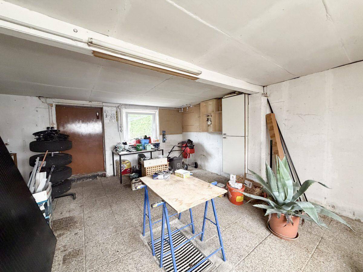 Geräumiger Werkstattbereich im Keller mit Arbeitsfläche und Stauraum.