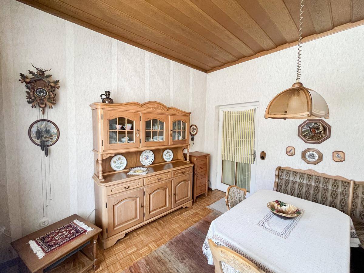 Gemütlicher Essbereich mit traditionellen Holzmöbeln, Holzbalkendecke und rustikaler Dekoration.