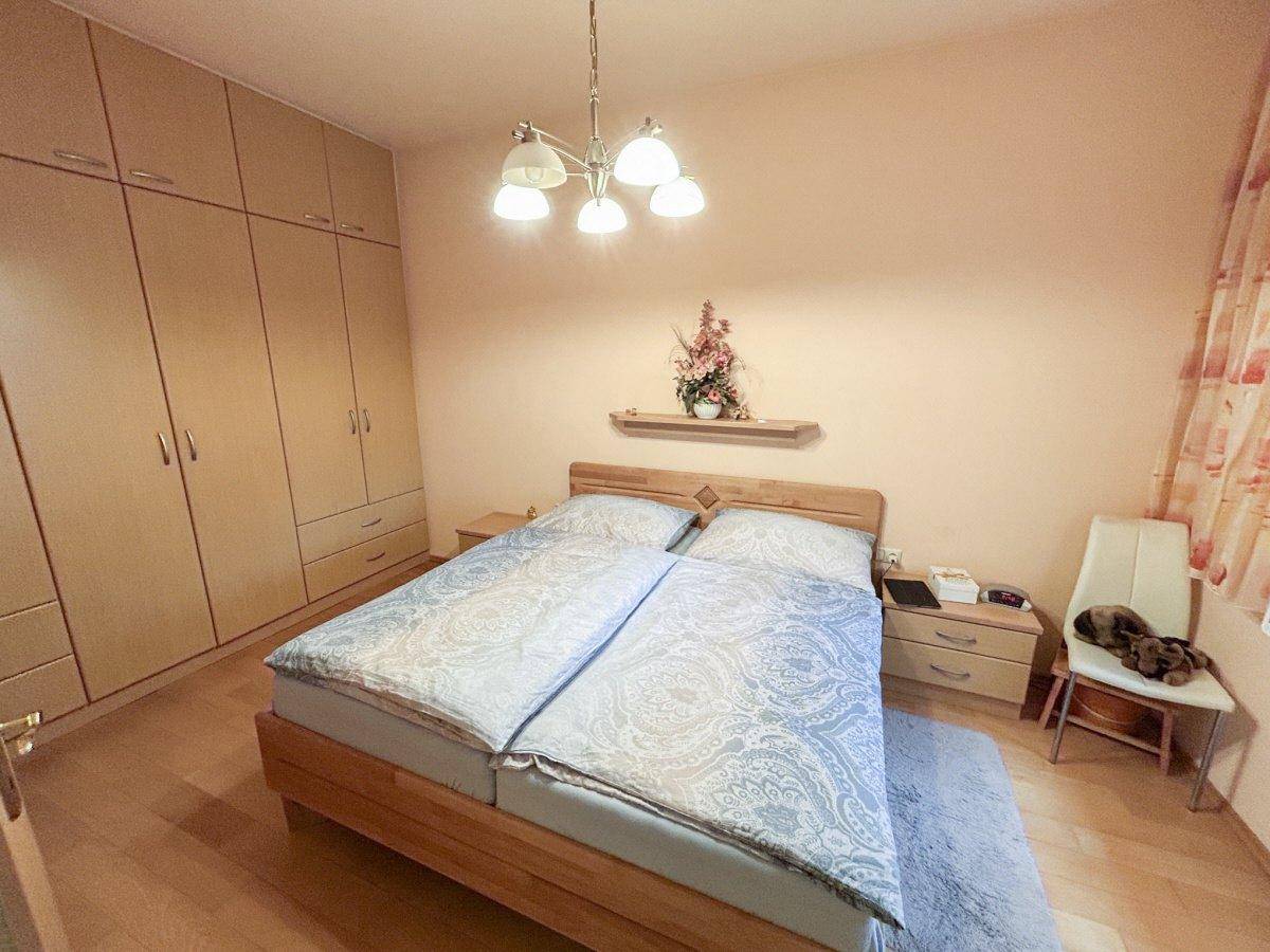 Helles Schlafzimmer mit Doppelbett, Einbauschränken und freundlicher Wandfarbe.