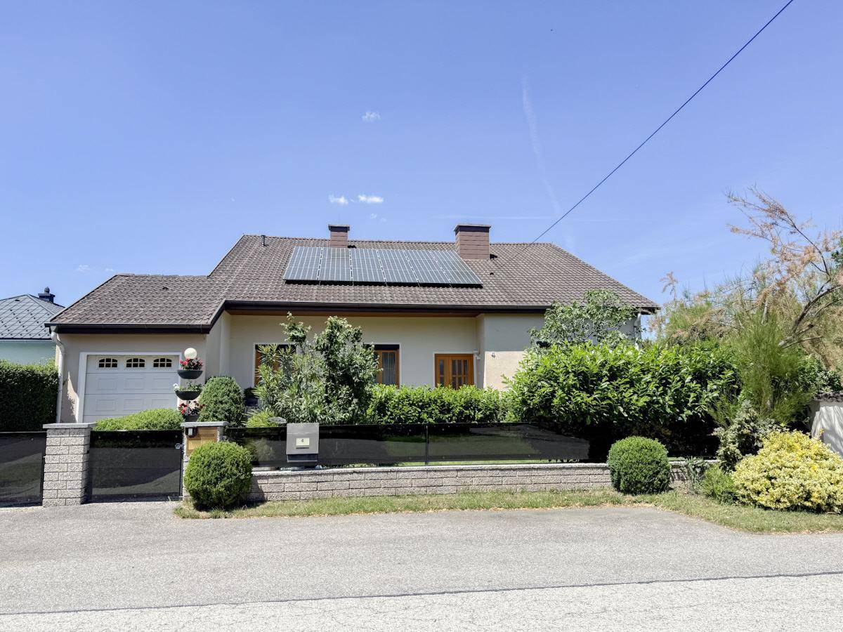 Vorderansicht des Hauses mit Solaranlage auf dem Dach und gepflegtem Vorgarten.