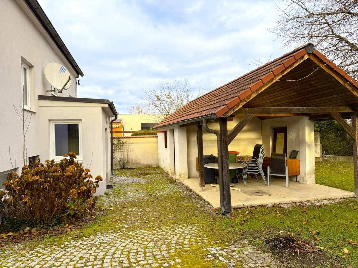 Überdachte Terrasse mit Sitzgelegenheiten und Blick auf den Gartenbereich.