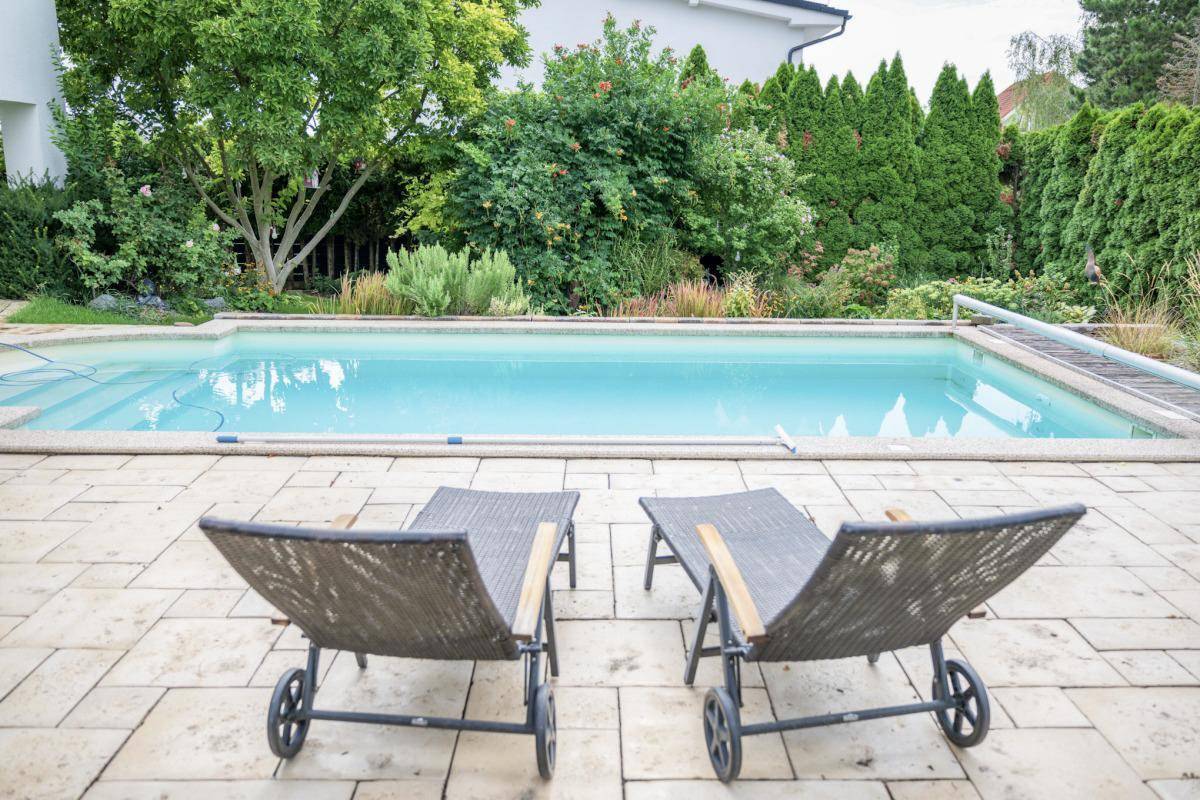 Entspannender Poolbereich mit Sonnenliegen und großzügiger Terrasse für Erholung im Freien.