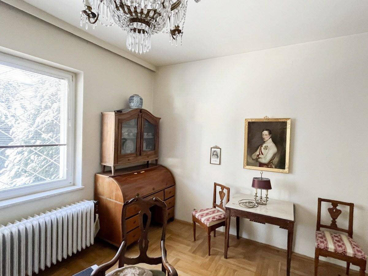 Klassisches Arbeitszimmer mit Parkettboden, antiken Möbeln und einem großen Fenster.