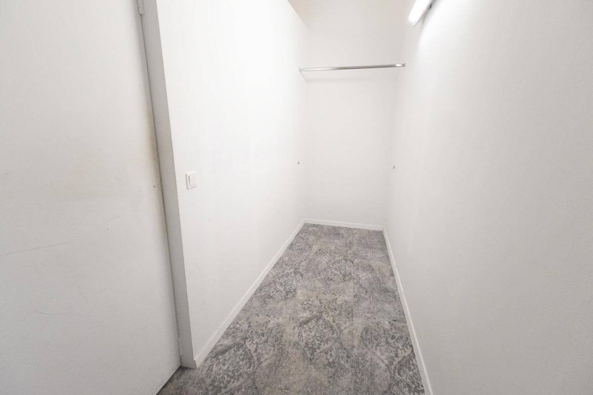 Kleiner, schlichter Raum mit einer Kleiderstange, geeignet als begehbarer Kleiderschrank oder Abstellkammer.