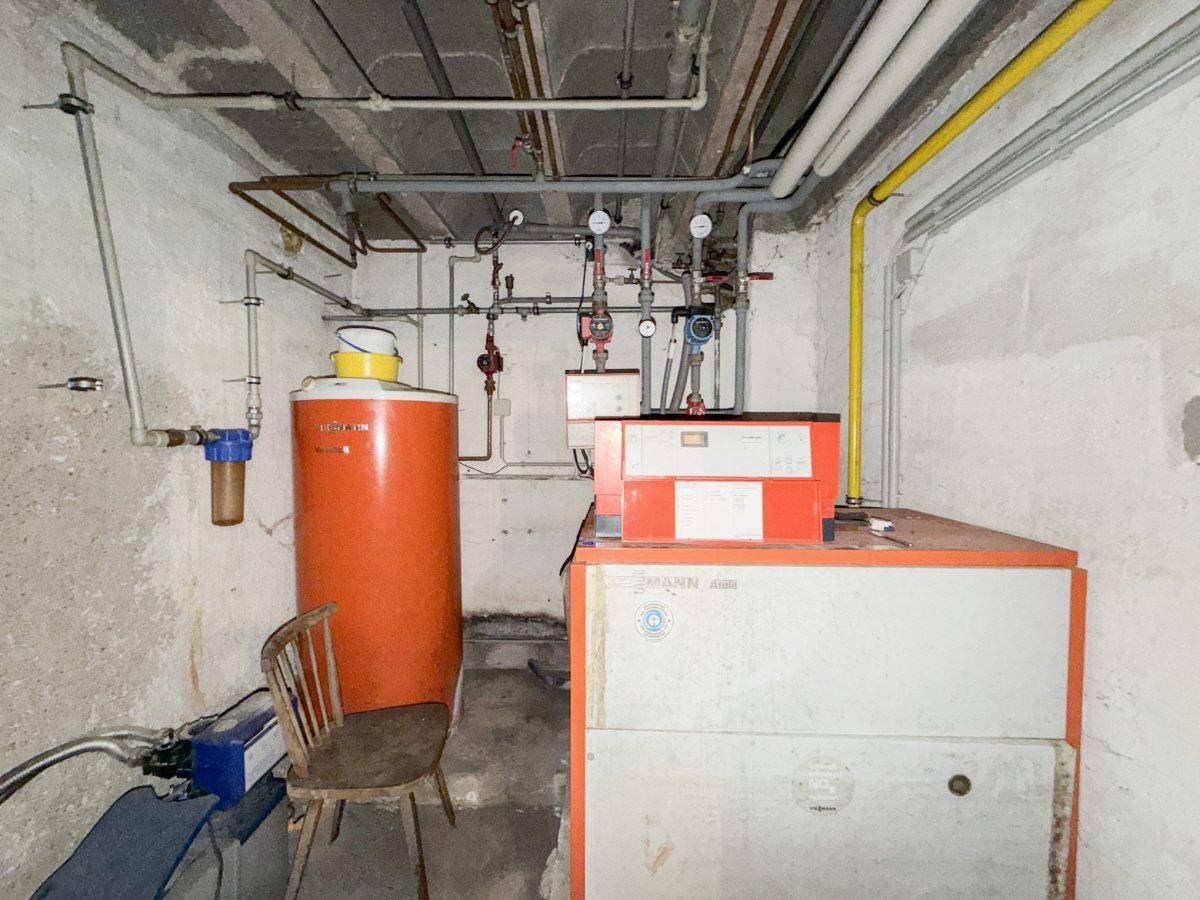 Heizungsraum im Keller mit Warmwasserspeicher und zentraler Heizanlage.