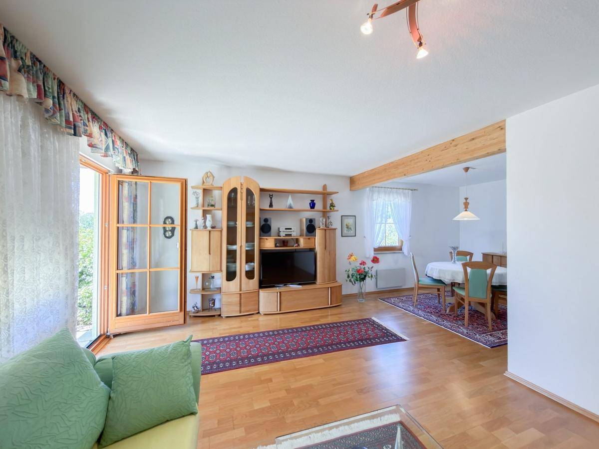 Offener Wohn- und Essbereich mit Holzboden und Zugang zur Terrasse.