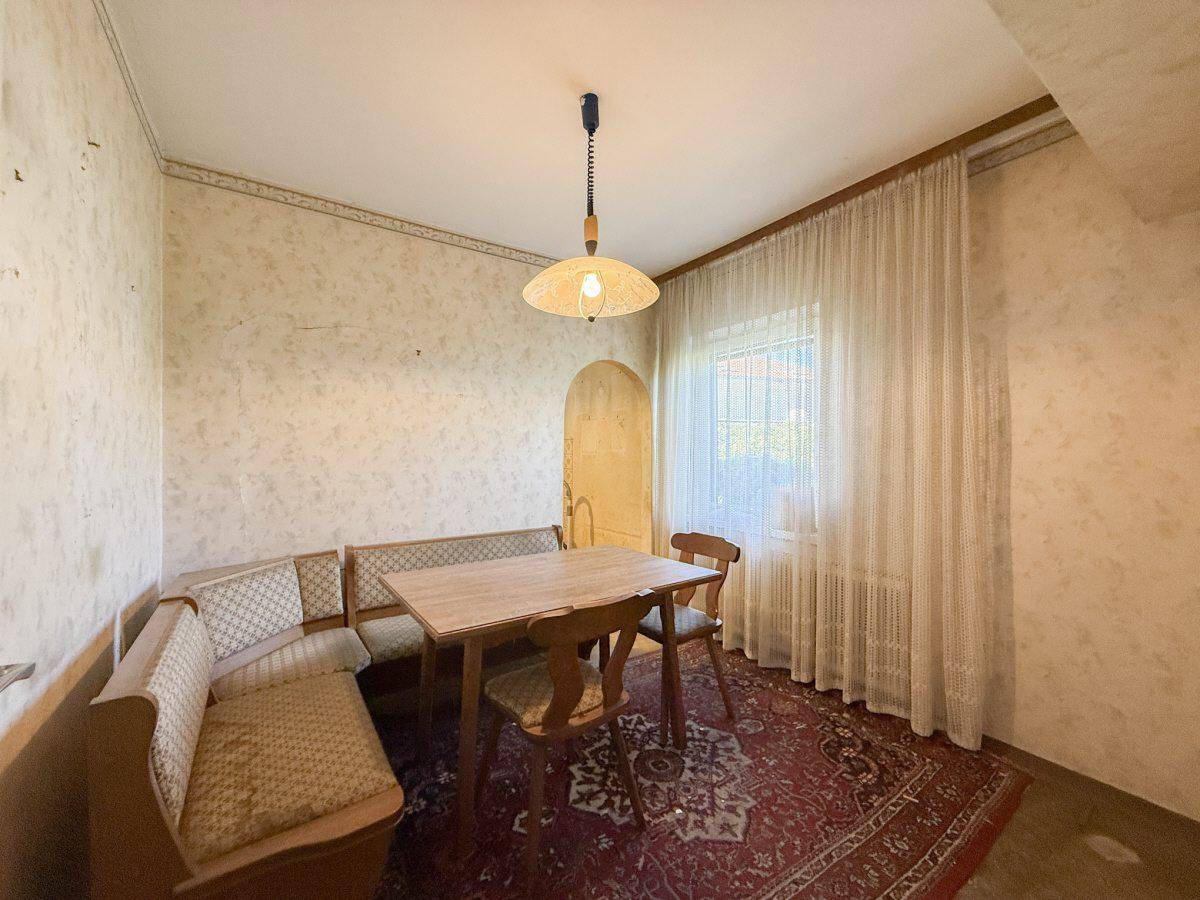 Gemütlicher Essbereich mit Holztisch, Eckbank und traditioneller Einrichtung.
