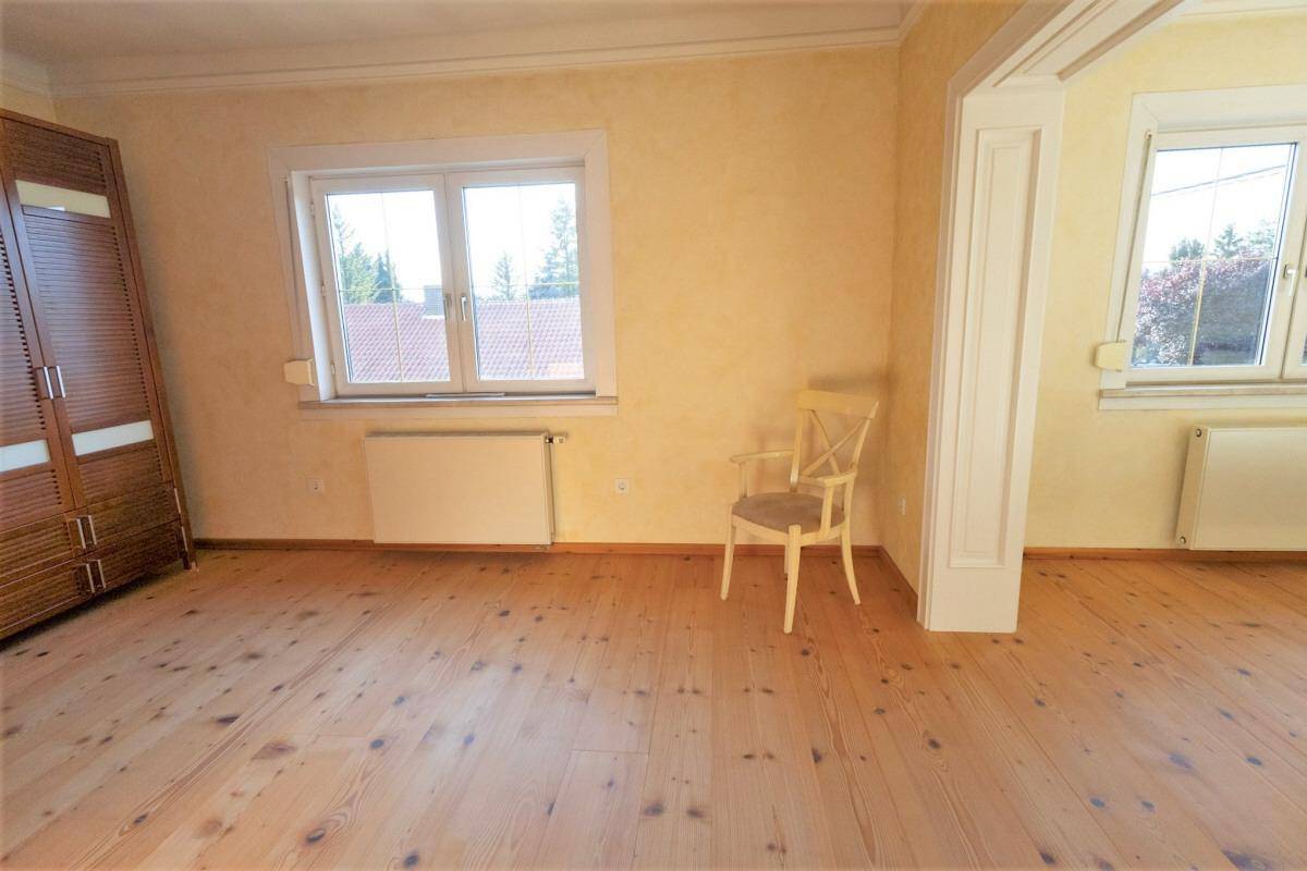 Heller Raum mit Holzdielenboden und einem großen Kleiderschrank.
