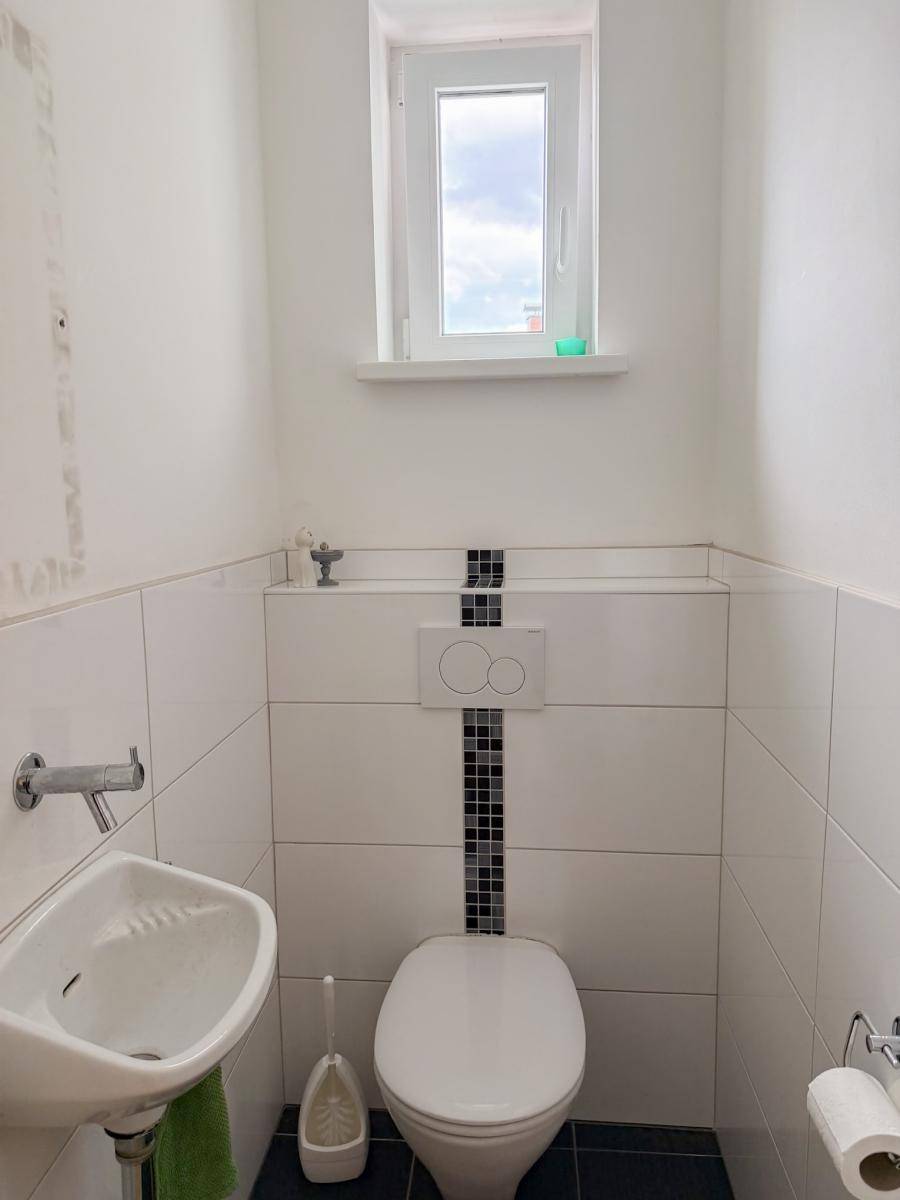 Kleines Gäste-WC mit Fenster, Wand-WC und modernem Design.