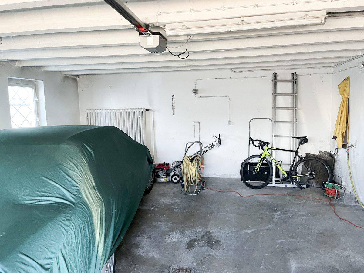 Geräumige Garage mit Betonboden, Werkzeugen und einem Fahrrad.