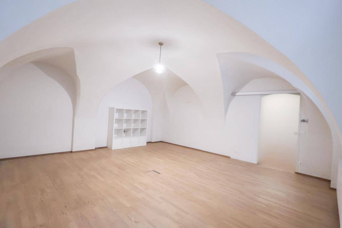 Großer, heller Raum mit beeindruckender Gewölbedecke und warmem Holzboden, vielseitig nutzbar.