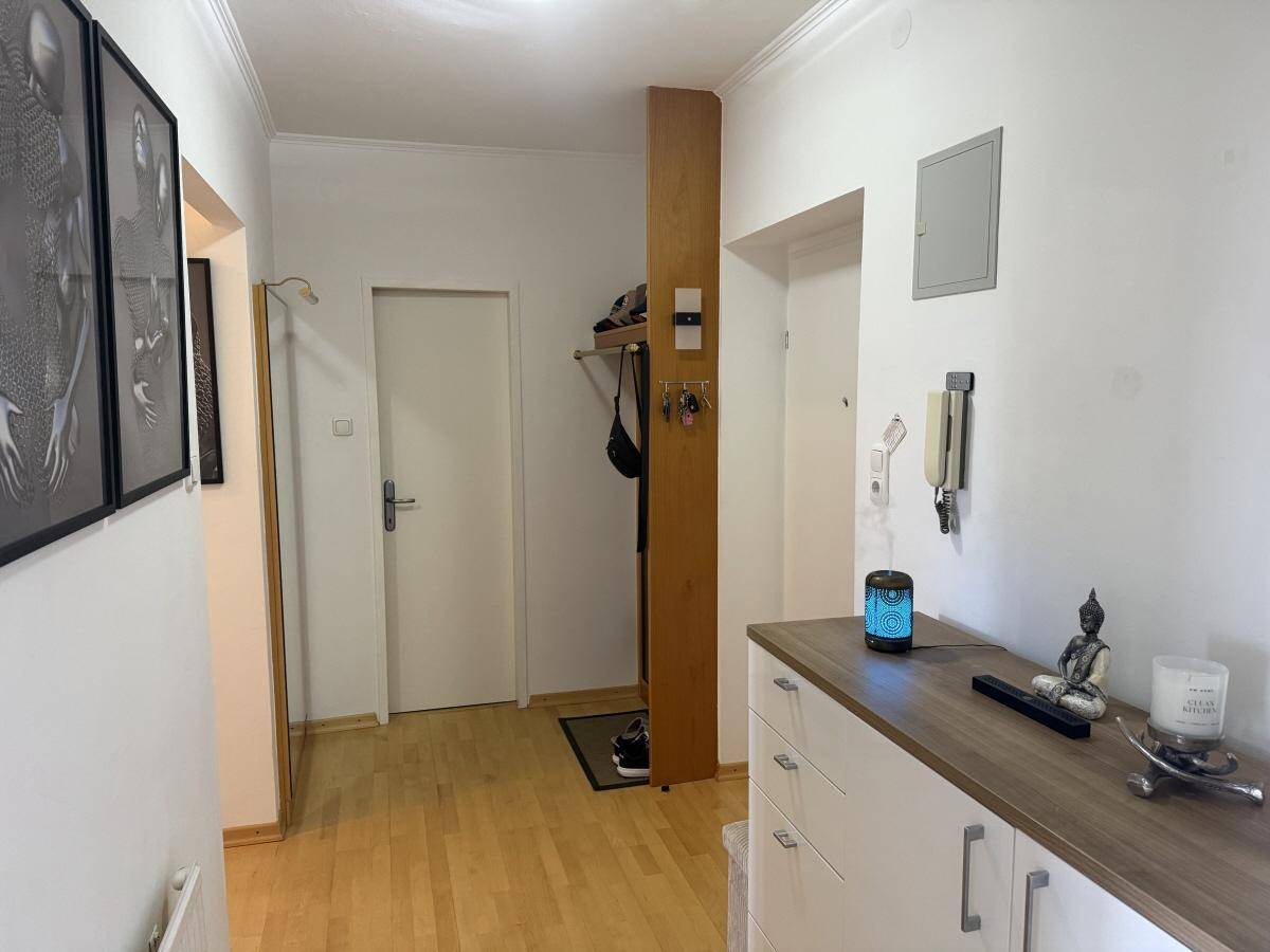 Eingangsbereich mit Garderobe, Kommode und dekorativen Elementen.