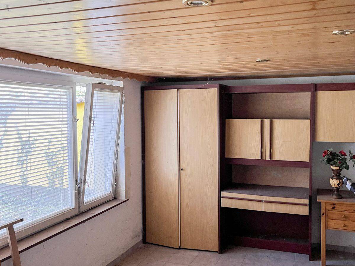 Raum mit Holzdecke, großen Fenstern und Einbauschränken, vielseitig nutzbar.