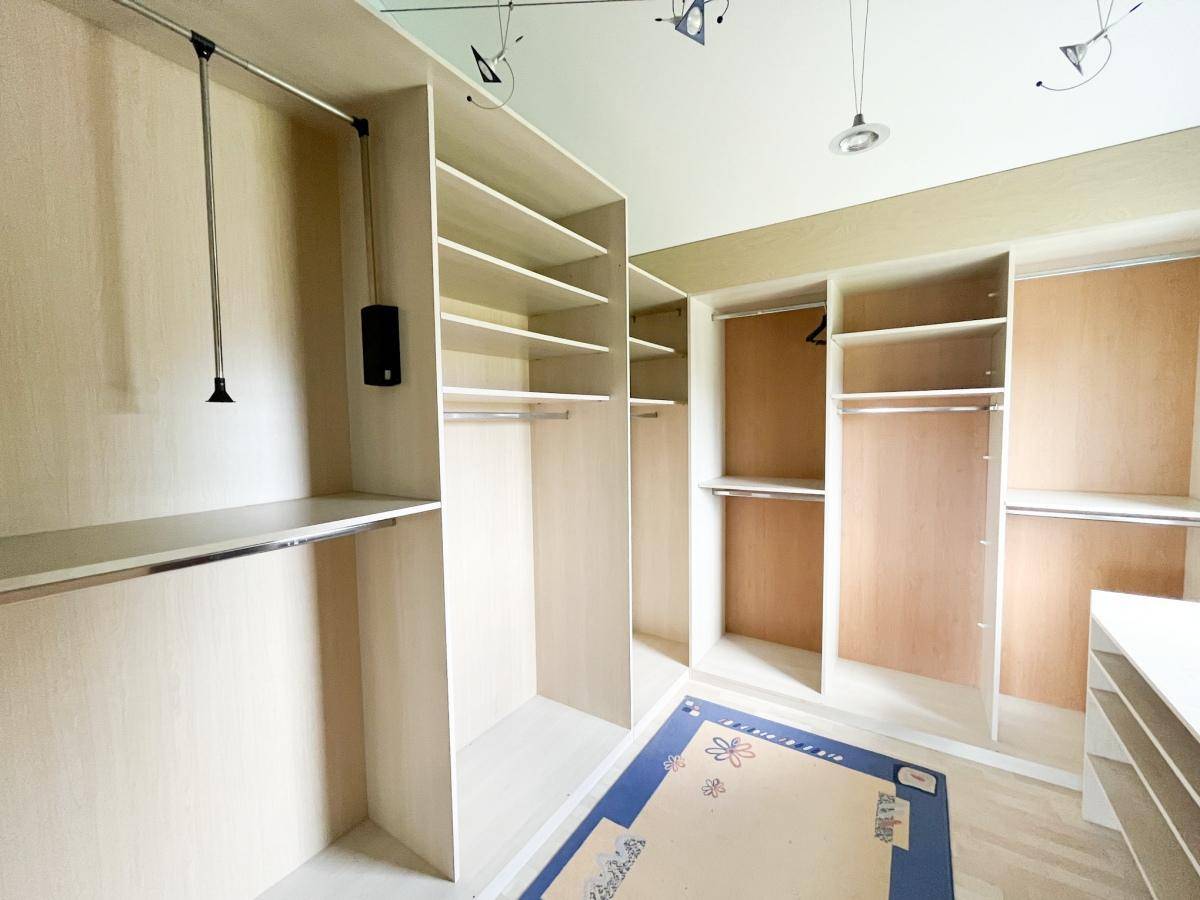 Geräumiger begehbarer Kleiderschrank mit Regalen und Kleiderstangen.