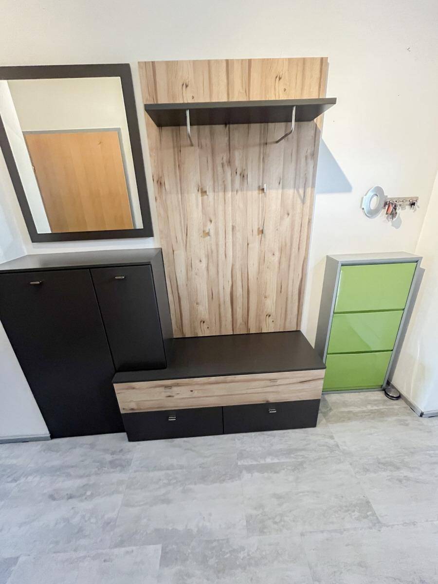 Eingangsbereich mit Garderobe, Spiegel und Schuhschränken, praktisch und modern.