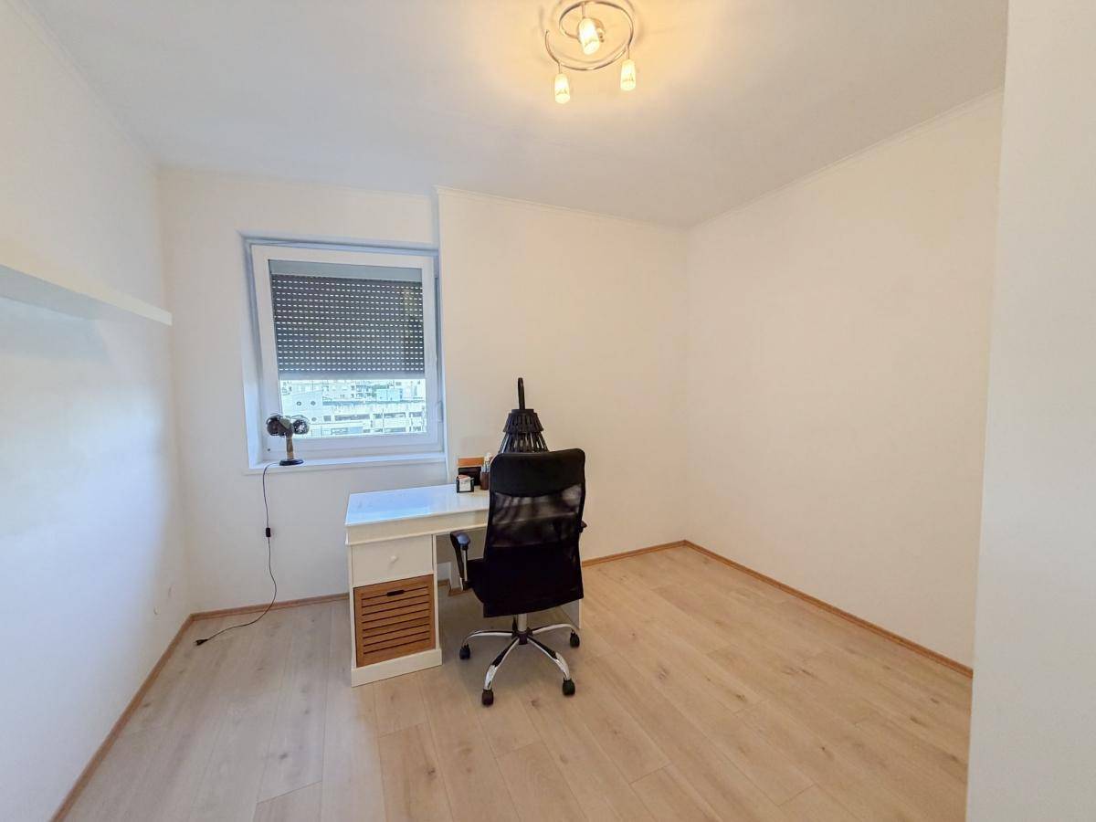 Funktionales Arbeitszimmer mit Schreibtisch, Bürostuhl und Fenster für Tageslicht.
