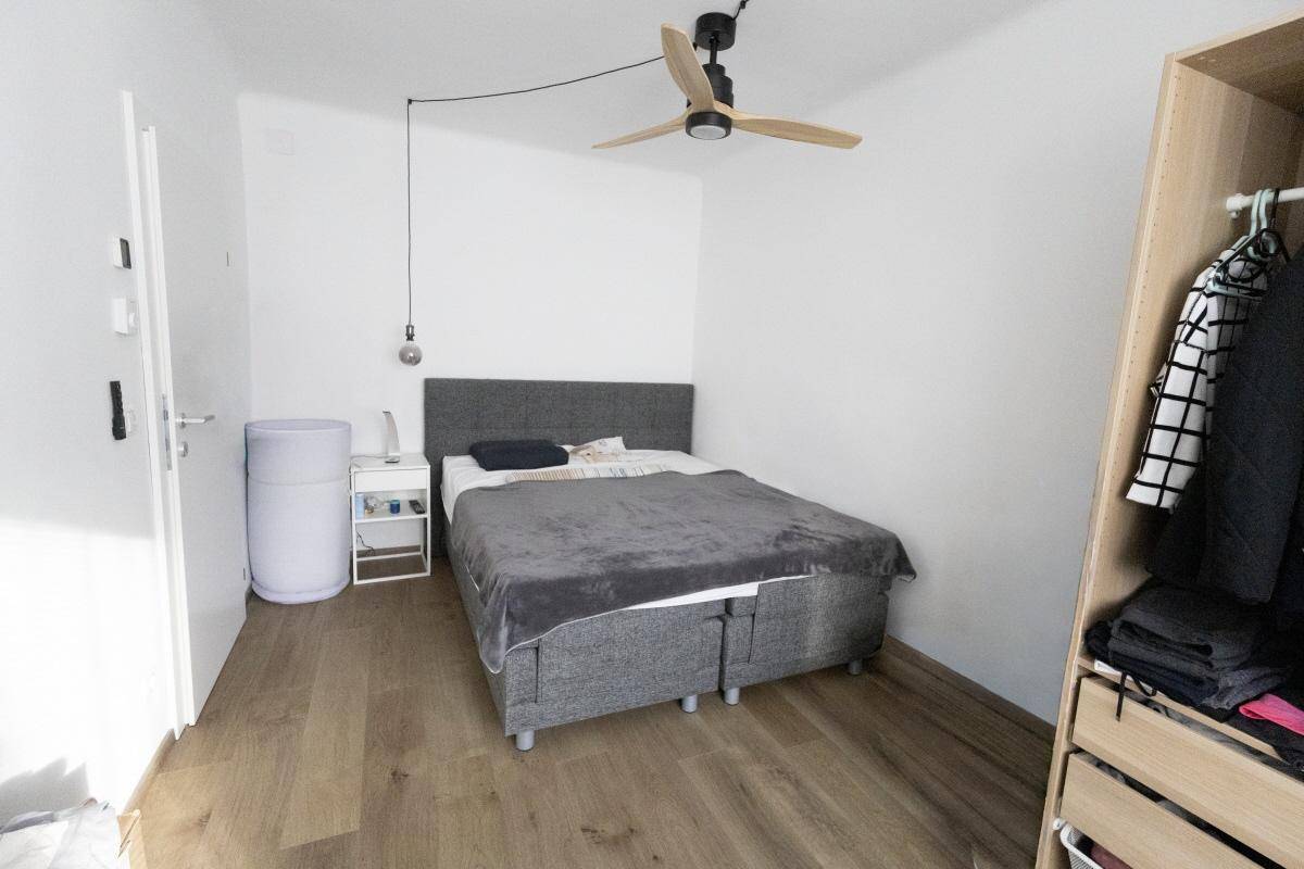 Schlafzimmer mit Doppelbett, Nachttisch und Deckenventilator für angenehmes Klima.