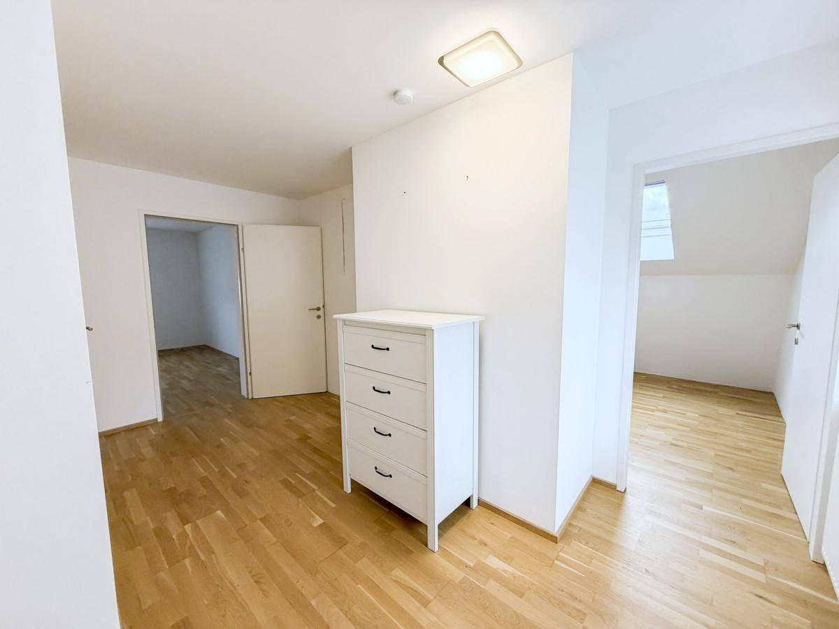 Schlafzimmer mit Holzboden und weißer Kommode, bietet vielseitige Nutzungsmöglichkeiten.