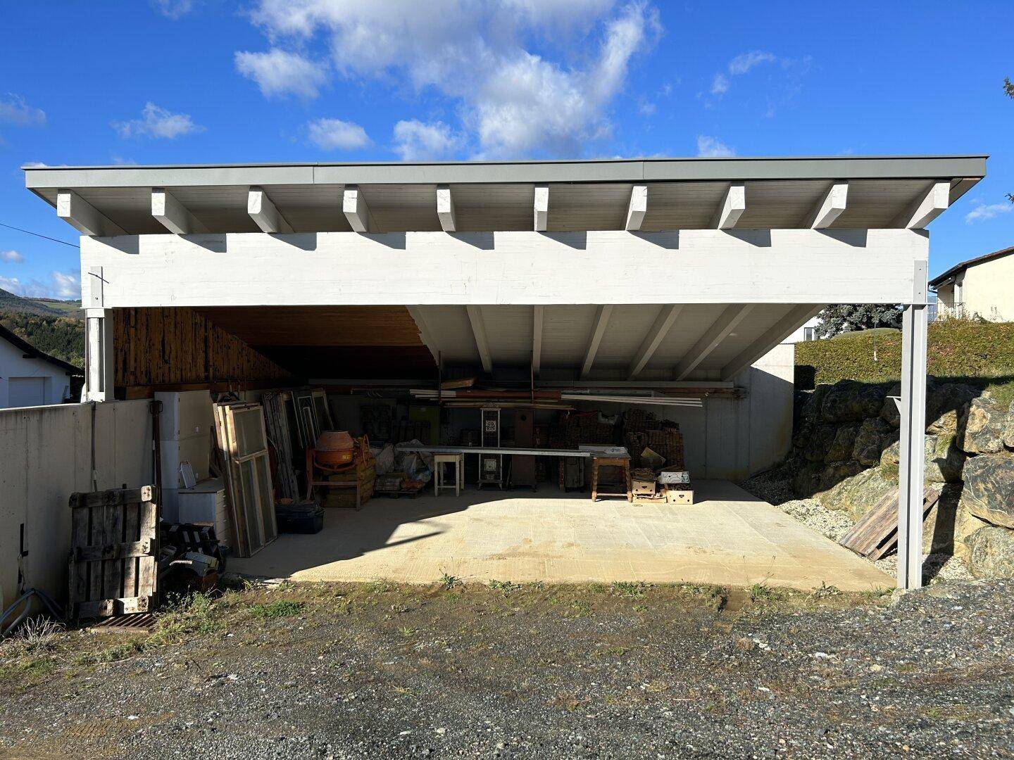 Geräumiger Carport mit Lagerfläche, ideal für Fahrzeuge und Gartengeräte.